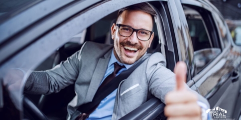 Man in his car giving a thumbs up outside his window.